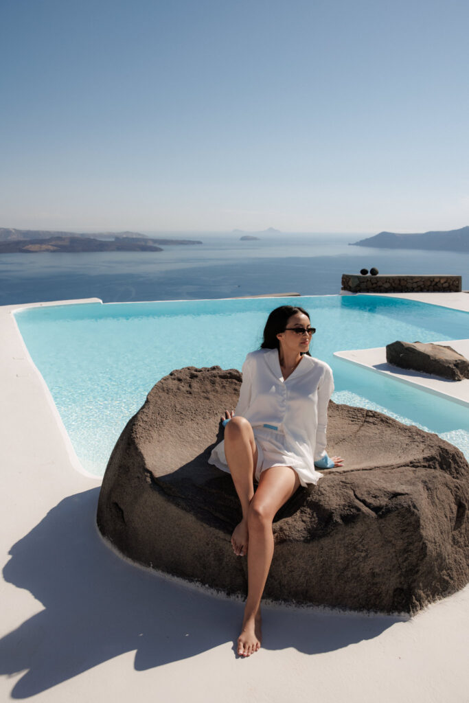 Bride relaxing by infinity pool.